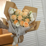 Champagne roses bouquet wrapped in brown paper with a white ribbon